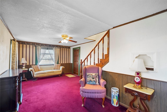 living area featuring ceiling fan, carpet flooring, and a textured ceiling