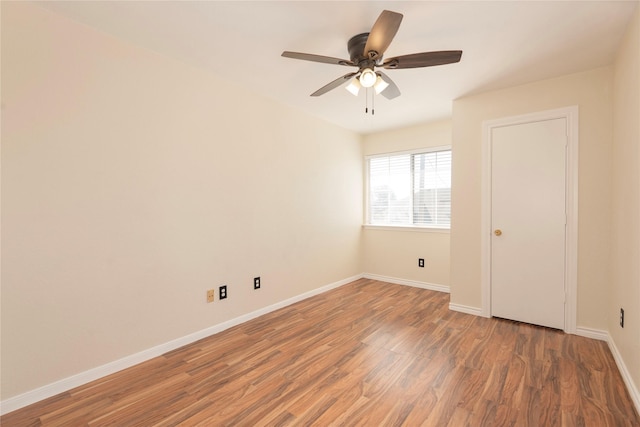 spare room featuring dark wood-type flooring and ceiling fan