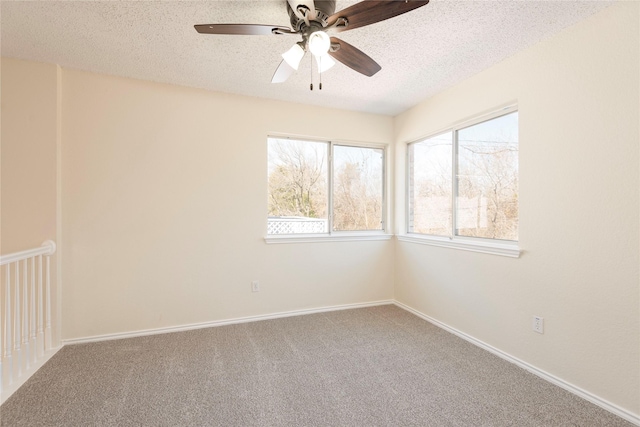 carpeted empty room with ceiling fan and a textured ceiling