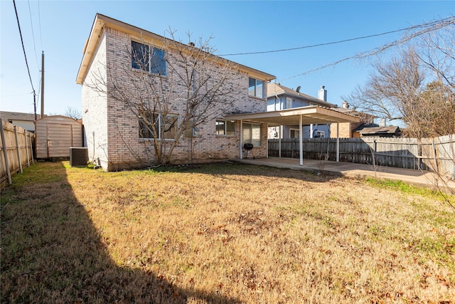 rear view of house featuring a storage unit, central AC unit, a patio area, and a lawn