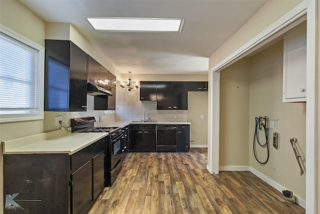 kitchen featuring sink, dark hardwood / wood-style flooring, pendant lighting, decorative backsplash, and black appliances