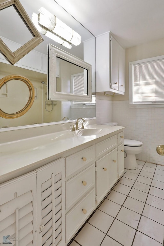 bathroom with vanity, toilet, tile patterned flooring, and tile walls