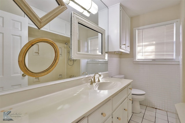 bathroom with tile walls, vanity, tile patterned floors, and toilet