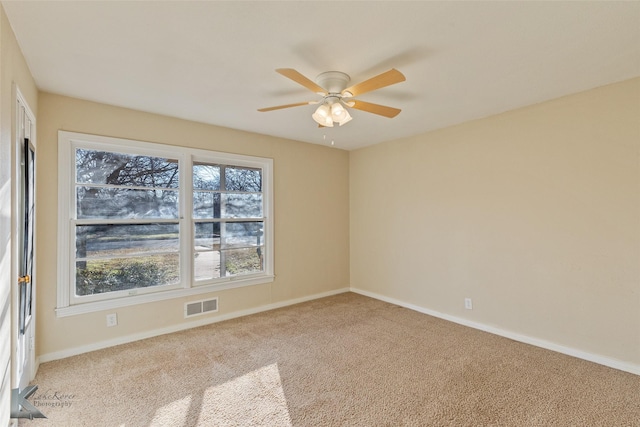 unfurnished room featuring a wealth of natural light, light colored carpet, and ceiling fan