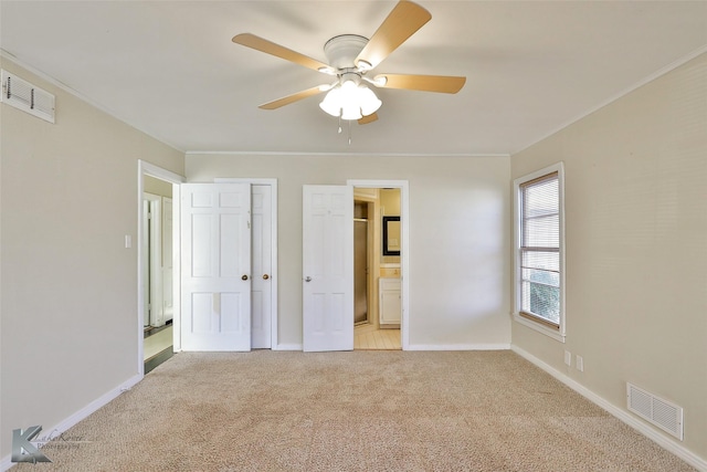 unfurnished bedroom featuring ceiling fan, ensuite bathroom, light colored carpet, and a closet