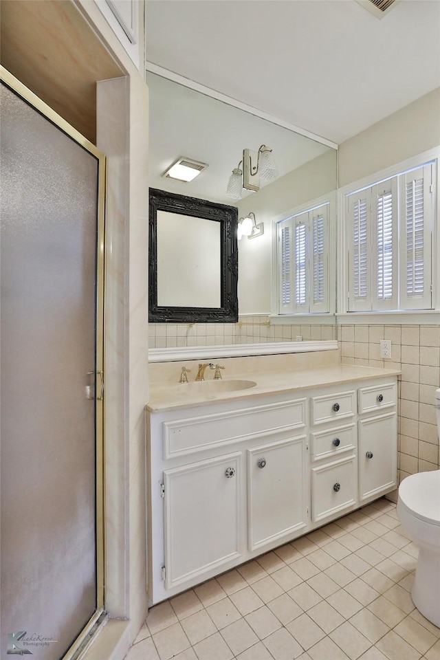 bathroom with tile patterned flooring, vanity, a shower with door, and toilet