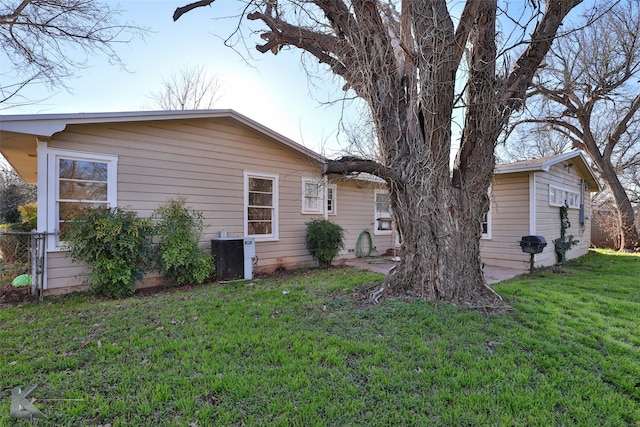 exterior space featuring cooling unit and a lawn