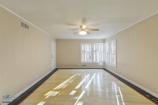 empty room featuring crown molding, wood-type flooring, and ceiling fan