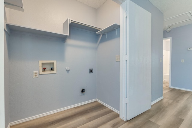 washroom with baseboards, hookup for a washing machine, wood finished floors, electric dryer hookup, and gas dryer hookup