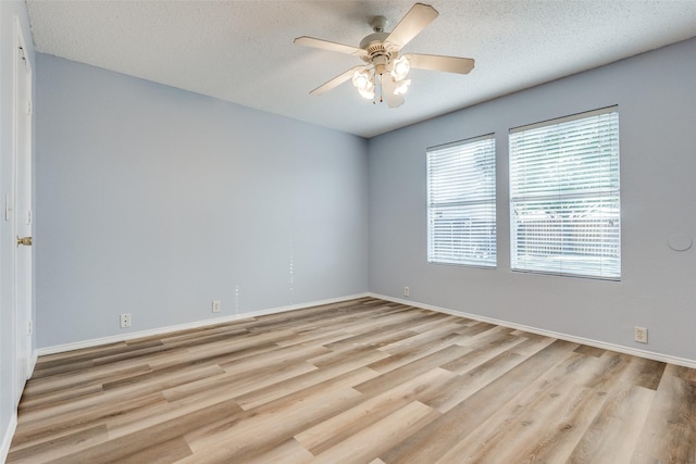 empty room featuring ceiling fan, baseboards, a textured ceiling, and light wood finished floors