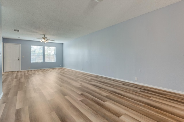 unfurnished living room featuring ceiling fan, light hardwood / wood-style floors, and a textured ceiling