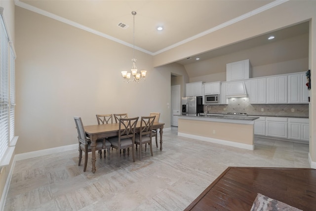 tiled dining area with an inviting chandelier, ornamental molding, and sink