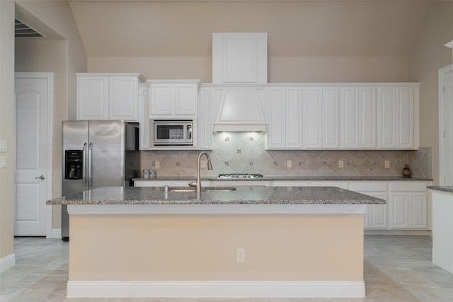 kitchen with appliances with stainless steel finishes, light stone countertops, and a kitchen island with sink