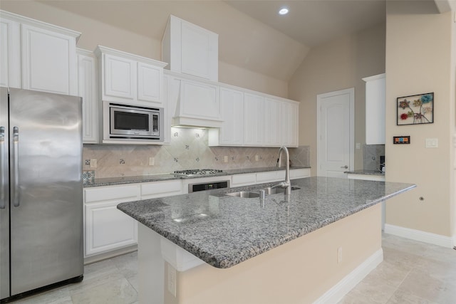 kitchen featuring dark stone countertops, appliances with stainless steel finishes, sink, and white cabinets