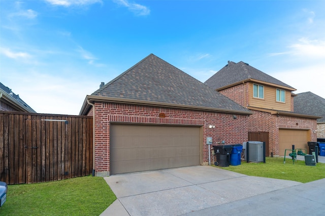 view of side of home with cooling unit, a garage, and a lawn