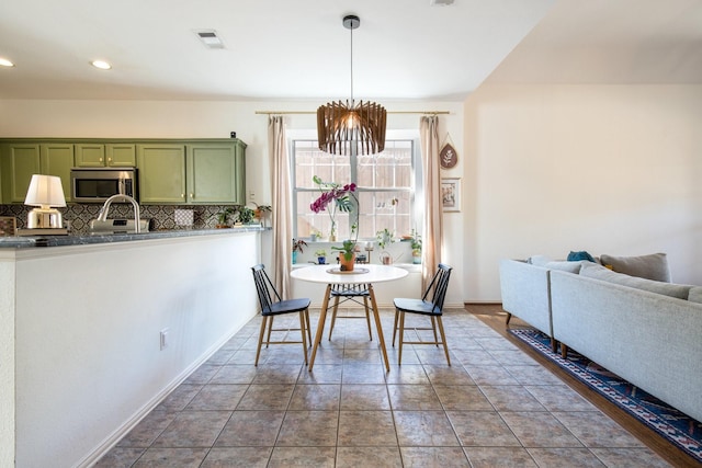 dining area with tile patterned flooring and an inviting chandelier