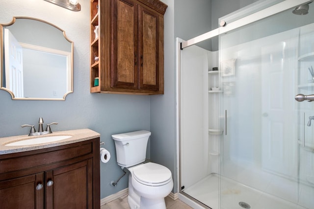 bathroom featuring vanity, a shower with door, and toilet