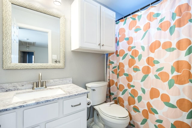 bathroom with vanity, curtained shower, and toilet