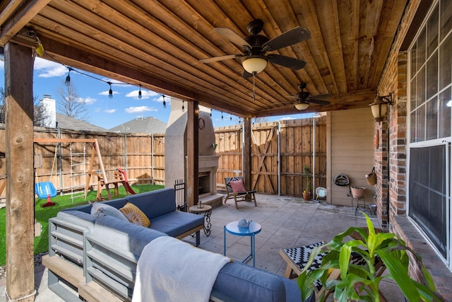 view of patio featuring ceiling fan and an outdoor living space with a fireplace