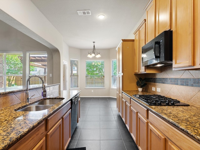 kitchen featuring sink, black appliances, a healthy amount of sunlight, and stone countertops