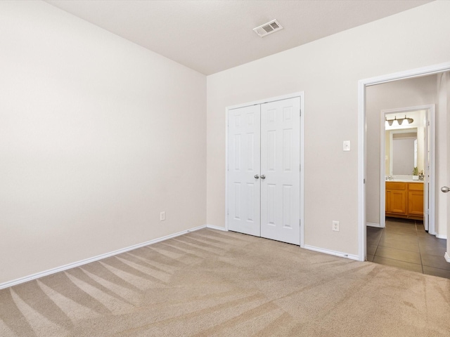 unfurnished bedroom featuring light carpet and a closet