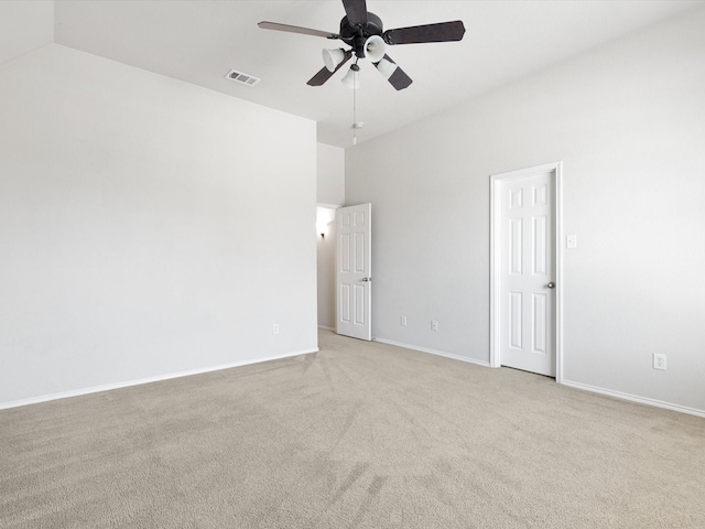 carpeted spare room with ceiling fan and high vaulted ceiling