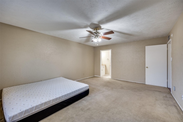 carpeted bedroom featuring a textured ceiling, ceiling fan, and ensuite bathroom