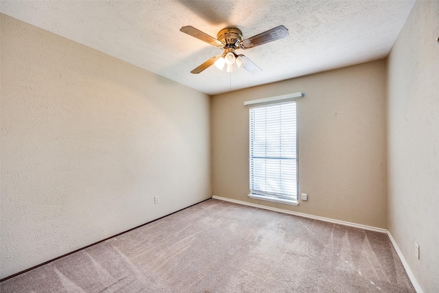 empty room with a textured ceiling, ceiling fan, and carpet