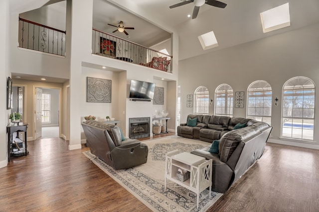 living room featuring plenty of natural light, a skylight, and a high ceiling