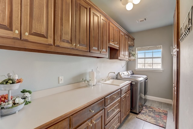 washroom featuring cabinets, washing machine and dryer, and sink