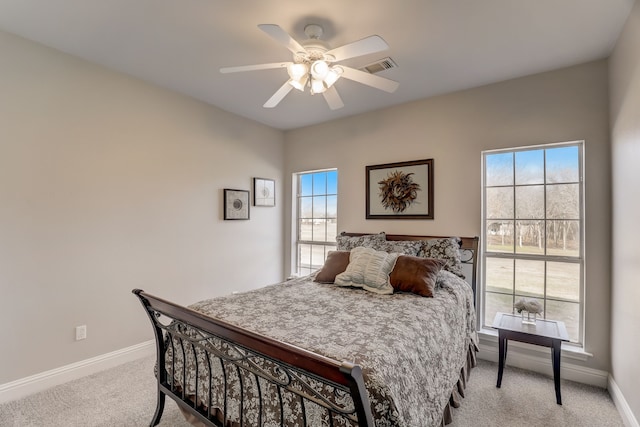 carpeted bedroom featuring ceiling fan and multiple windows