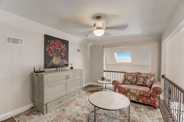 living room featuring a skylight and ceiling fan