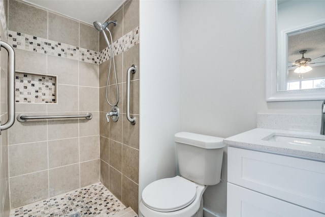 bathroom featuring vanity, ceiling fan, toilet, and a tile shower