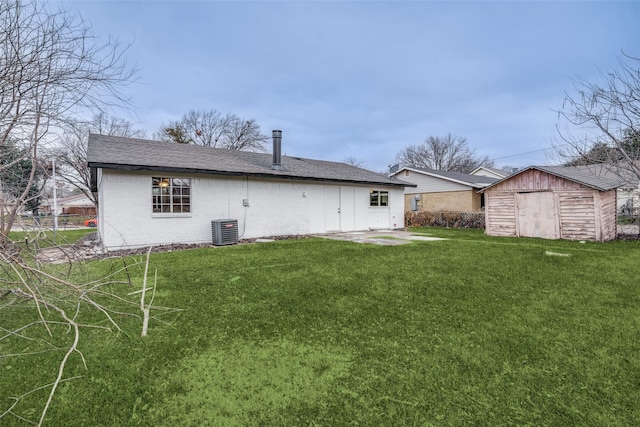 rear view of property featuring a shed, a yard, central AC, and a patio