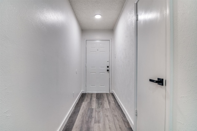 hall featuring a textured ceiling and light wood-type flooring