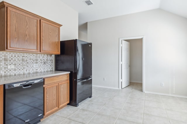 kitchen with vaulted ceiling, light tile patterned floors, decorative backsplash, and black appliances