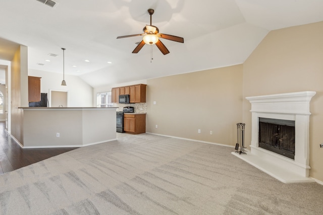 unfurnished living room featuring light carpet, vaulted ceiling, and ceiling fan