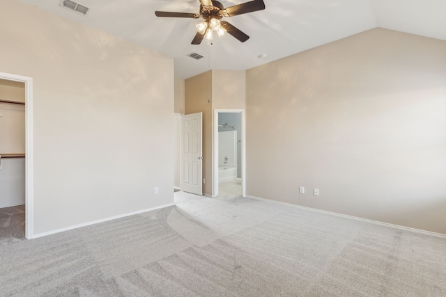 unfurnished bedroom with ensuite bath, ceiling fan, a walk in closet, light colored carpet, and a closet