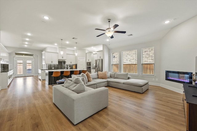 living room with light hardwood / wood-style flooring and ceiling fan