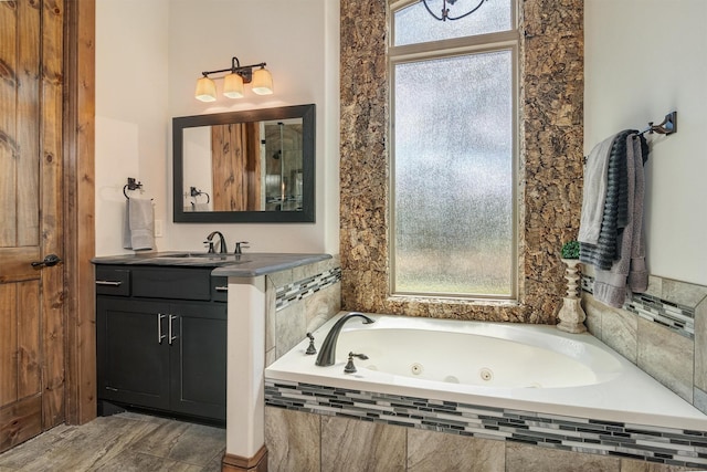 bathroom with a relaxing tiled tub and vanity