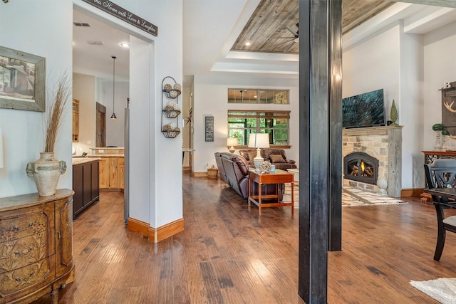 hall with a tray ceiling and dark hardwood / wood-style flooring