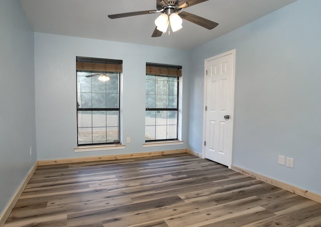 empty room featuring ceiling fan and dark hardwood / wood-style flooring