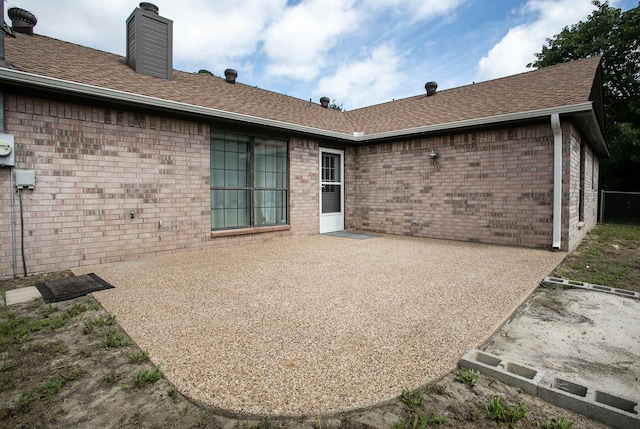 2048 County Road 3540, Hawkins, TX 75765 - back of house with a chimney, brick siding, and a patio
