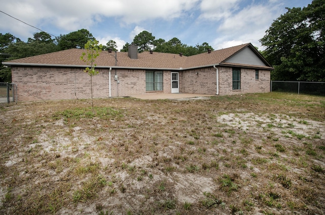 rear view of property with a patio and a yard