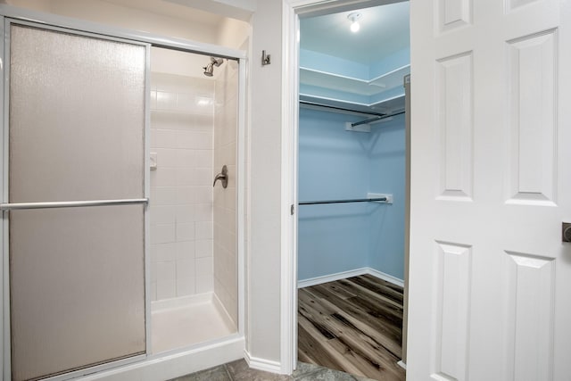 2048 County Road 3540, Hawkins, TX 75765 - full bath with a walk in closet, baseboards, wood finished floors, and a stall shower