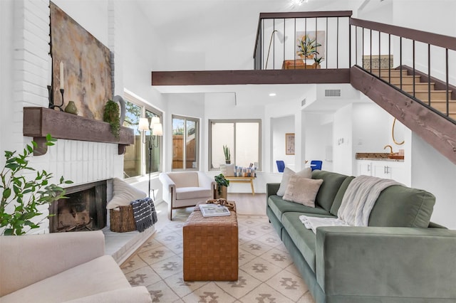 living room featuring a brick fireplace and high vaulted ceiling