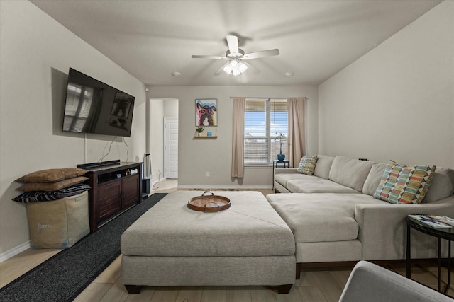 living room with baseboards, ceiling fan, and wood finished floors