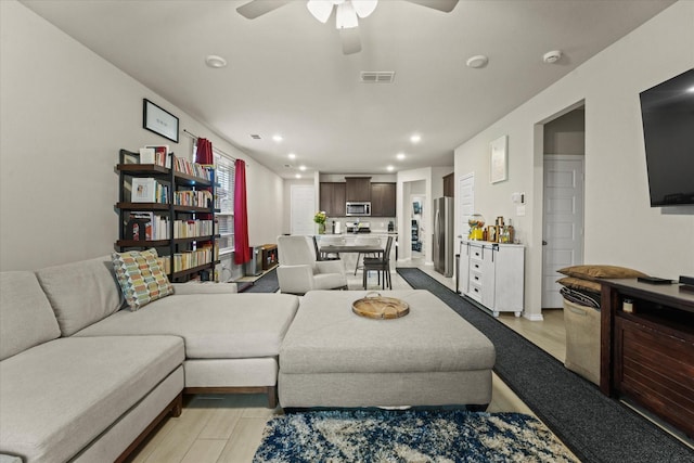 living area featuring a ceiling fan, recessed lighting, and light wood-style flooring