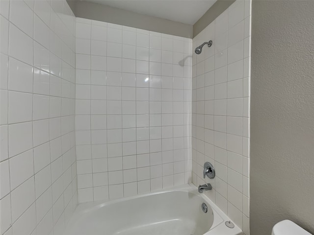 2002 Grimes Dr, Forney, TX 75126 - full bath with toilet, shower / washtub combination, and a textured wall