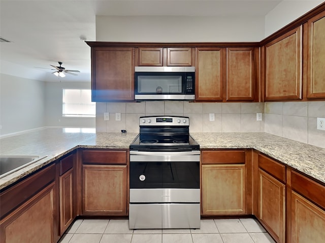 2002 Grimes Dr, Forney, TX 75126 - kitchen with stainless steel appliances, ceiling fan, light tile patterned floors, and backsplash